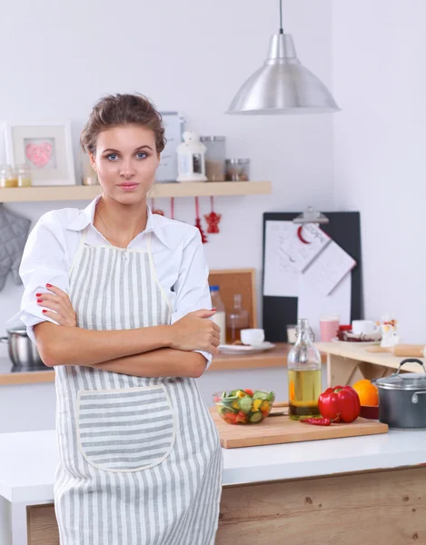 Lachende jonge vrouw in de keuken, staande op Kerstmis achtergrond — Stockfoto