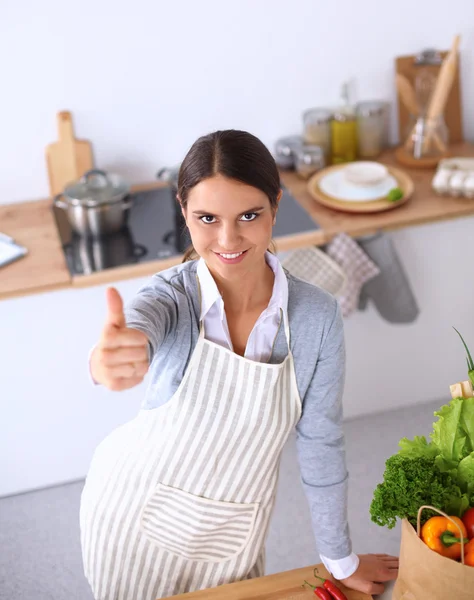 Vrouw in schort staande op het Bureau met kruidenier bagand weergegeven: ok — Stockfoto