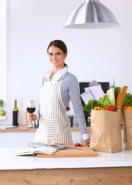 Vrouw met boodschappentassen in de keuken thuis, bij het bureau — Stockfoto