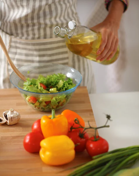 Sorridente giovane donna mescolando insalata fresca — Foto Stock