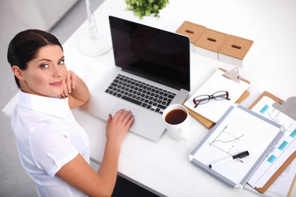 Aantrekkelijke zakenvrouw zit op het bureau in het kantoor — Stockfoto