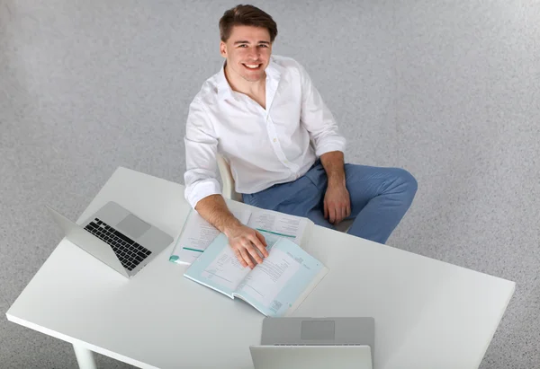 Joven hombre de negocios trabajando en la oficina, sentado en el escritorio — Foto de Stock