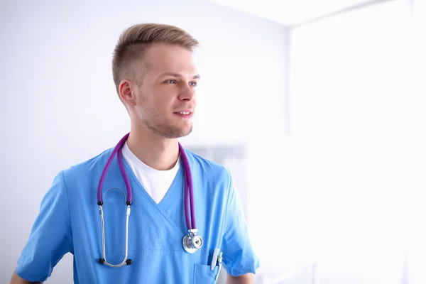 Médico com estetoscópio em pé, sobre fundo branco — Fotografia de Stock