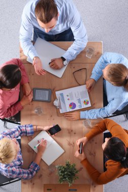 İş adamları iş toplantısında, ofiste oturup tartışıyorlar.