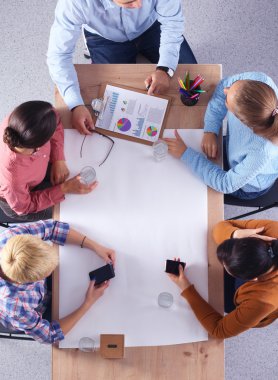 İş adamları iş toplantısında, ofiste oturup tartışıyorlar.