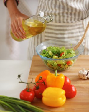 Gülümseyen genç kadın taze salata hazırlıyor.