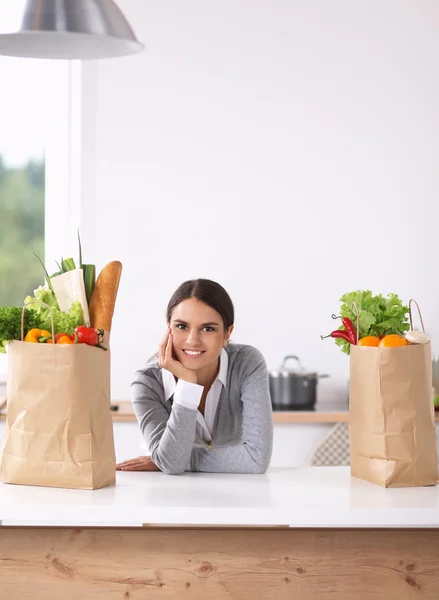 Portrait of a smiling woman cooking in her kitchen sitting — Stock Photo, Image