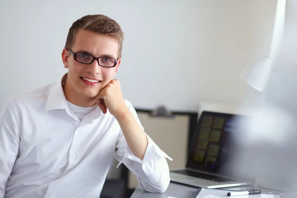 Ung affärsman arbetar på kontor, står nära skrivbord — Stockfoto