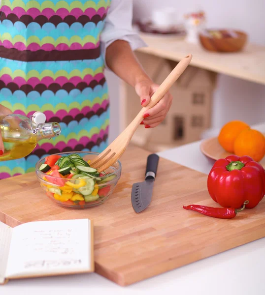 Sorridente giovane donna mescolando insalata fresca — Foto Stock