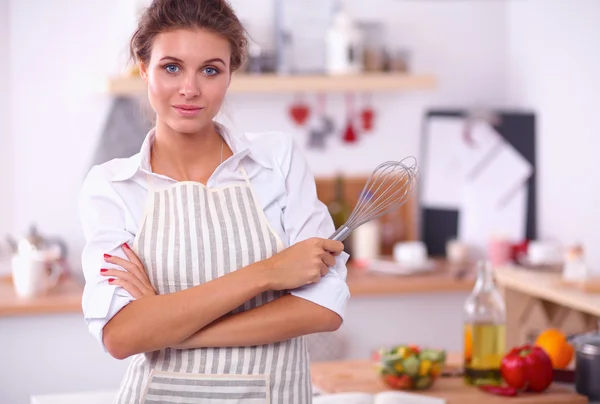 Sorridente giovane donna in cucina, in piedi su sfondo natalizio — Foto Stock