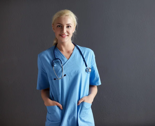 若い医者の聴診器を踏んで灰色の背景を持つ女性 — ストック写真