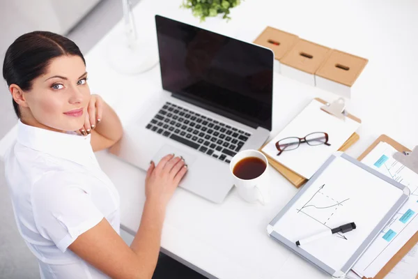 Aantrekkelijke zakenvrouw zit op het bureau in het kantoor — Stockfoto