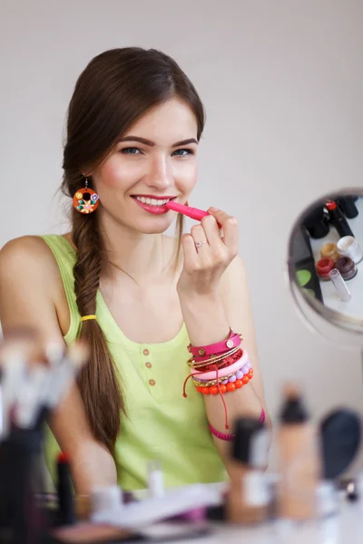 Wanita cantik membuat make-up dekat cermin, duduk di meja — Stok Foto