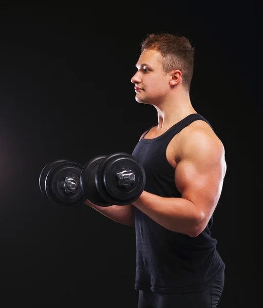 Schöner muskulöser Mann, der mit Hanteln trainiert — Stockfoto