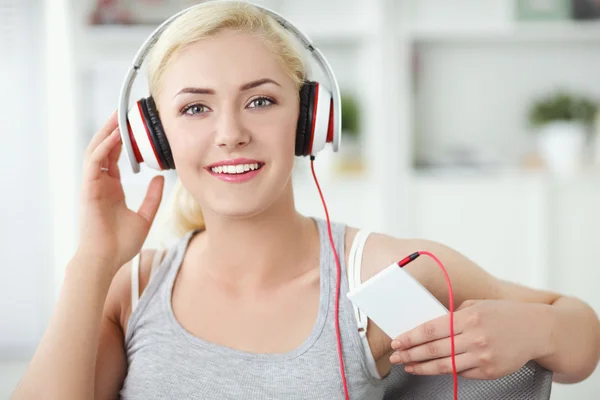 Joven hermosa mujer en casa sentada en el sofá y escuchando música —  Fotos de Stock