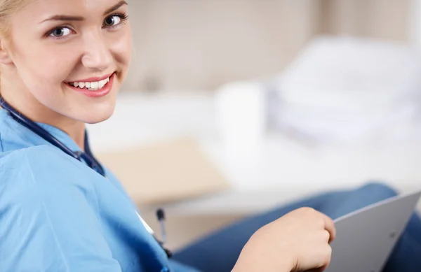 Portrait of a happy young doctor sitting on the sofa — Stock Photo, Image