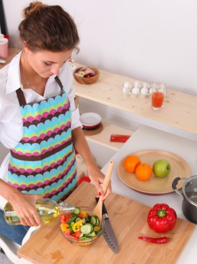 Gülümseyen genç kadın taze salata hazırlıyor.