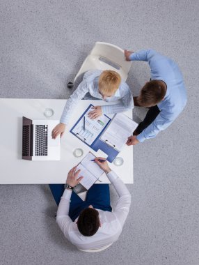 İş adamları iş toplantısında, ofiste oturup tartışıyorlar.