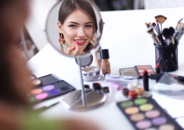 Genç güzel kadın ayna, Masa başında oturan yakınındaki makyaj yapma