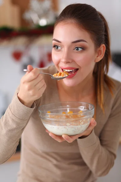 Smiling attractive woman having breakfast in kitchen interior — Stock Photo, Image