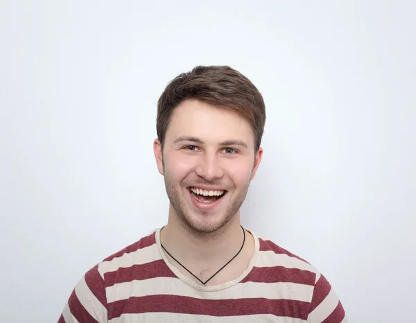 Portrait of young man smiling isolated on gray background — Stock Photo, Image