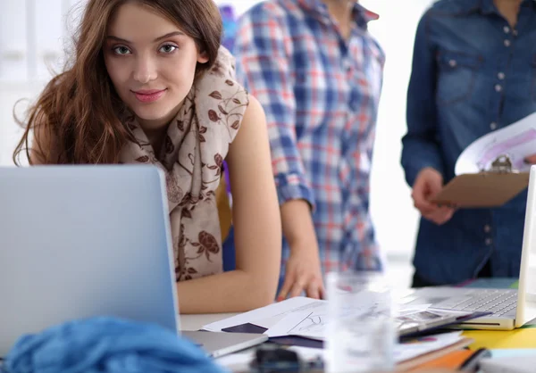 Giovane attraente stilista di moda femminile che lavora alla scrivania dell'ufficio, disegnando mentre parla sul cellulare — Foto Stock