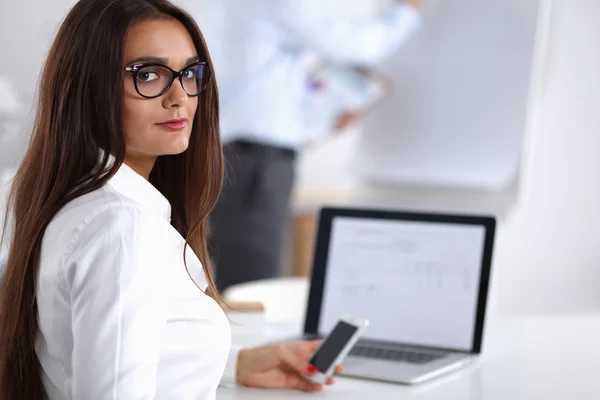 Empresária atraente sentada na mesa no escritório — Fotografia de Stock