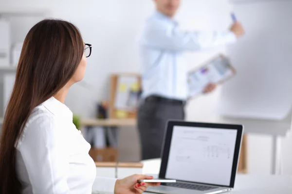 Attractive businesswoman sitting  on desk in the office — Stock Photo, Image