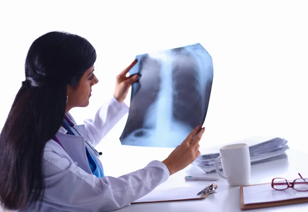 Jovem médica estudando imagem de raios-x, sentada na mesa — Fotografia de Stock
