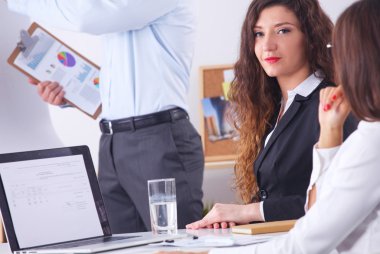 İş adamları iş toplantısında, ofiste oturup tartışıyorlar.