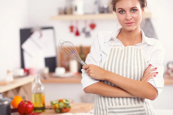 Sorridente giovane donna in cucina, in piedi su sfondo natalizio — Foto Stock