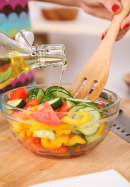 Genç kadın taze salata hazırlıyor.