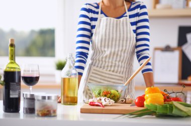 Genç kadın taze salata hazırlıyor.