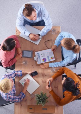 İş adamları iş toplantısında, ofiste oturup tartışıyorlar.