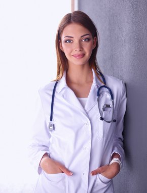 Steteskobu olan doktor kadın gri arka planda izole edilmiş.