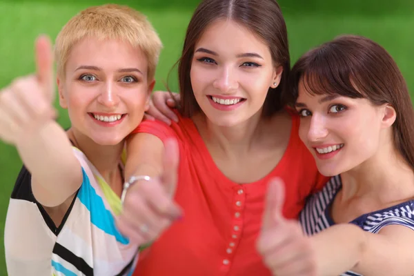 Drie meisjes vrienden gebaren duimen omhoog — Stockfoto