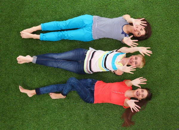 Young women lying on green grass — Stock Photo, Image