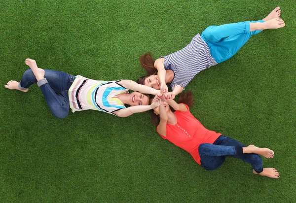 Mujeres jóvenes tumbadas sobre hierba verde — Foto de Stock