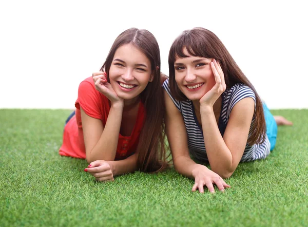 Dos mujeres jóvenes tumbadas sobre hierba verde — Foto de Stock