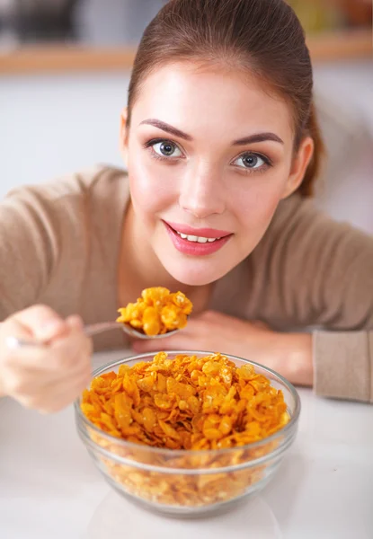 Усміхнена приваблива жінка снідає в інтер'єрі кухні — стокове фото