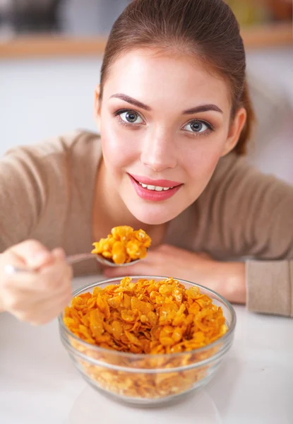 Leende attraktiv kvinna som äter frukost i köket interiör — Stockfoto