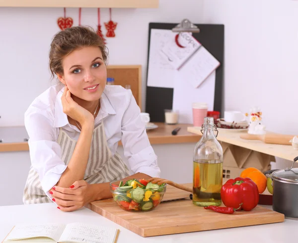 Mujer joven comiendo ensalada fresca en la cocina moderna — Foto de Stock