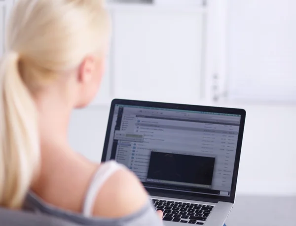 Giovane bella donna che utilizza un computer portatile a casa — Foto Stock