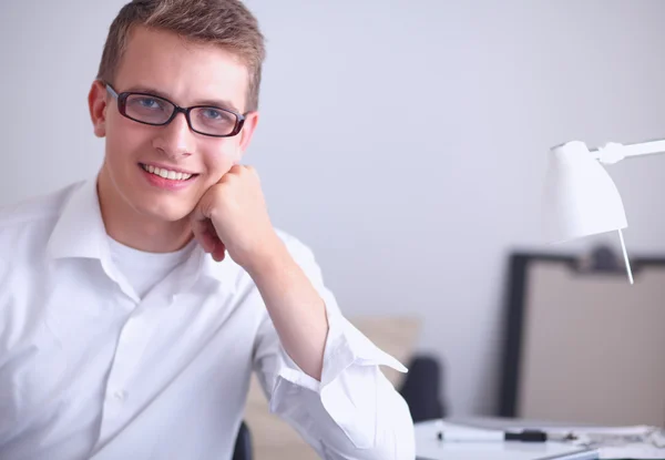 Ung affärsman arbetar på kontor, står nära skrivbord — Stockfoto