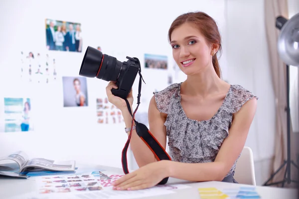 Ung kvinna fotograf bearbetning bilder sitter på skrivbordet — Stockfoto