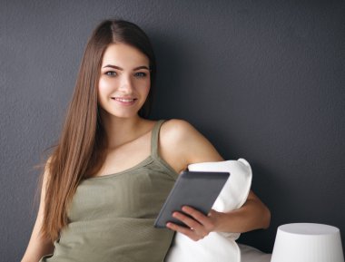 bir yastık ve uçak tablo ile katta oturan güzel esmer kadın