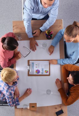 İş adamları iş toplantısında, ofiste oturup tartışıyorlar.