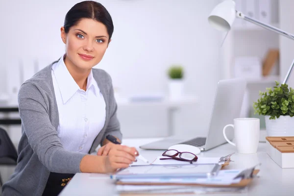 Attraktiv affärskvinna sitter på skrivbordet på kontoret — Stockfoto