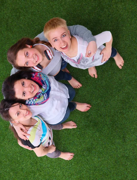 Quatre jeunes femmes debout sur l'herbe verte — Photo