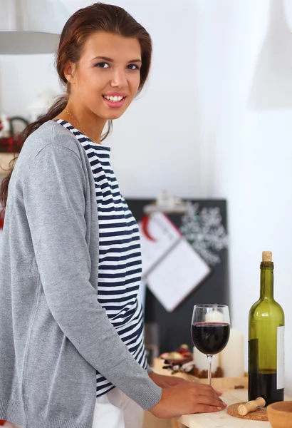 Smiling young woman in the kitchen, isolated on christmas background — Stock Photo, Image